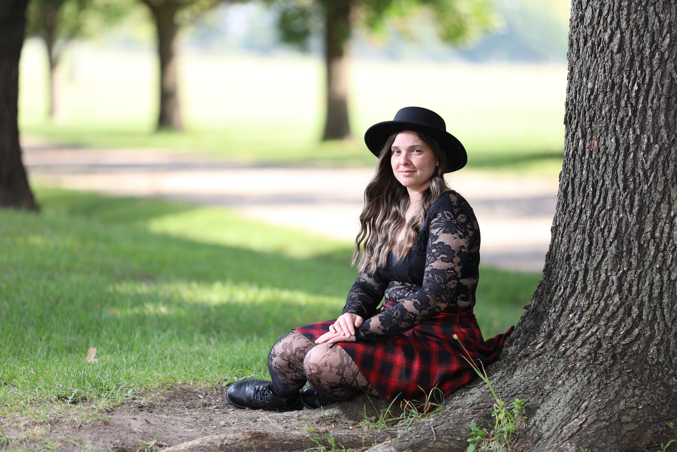 Creative portrait seated beside a tree