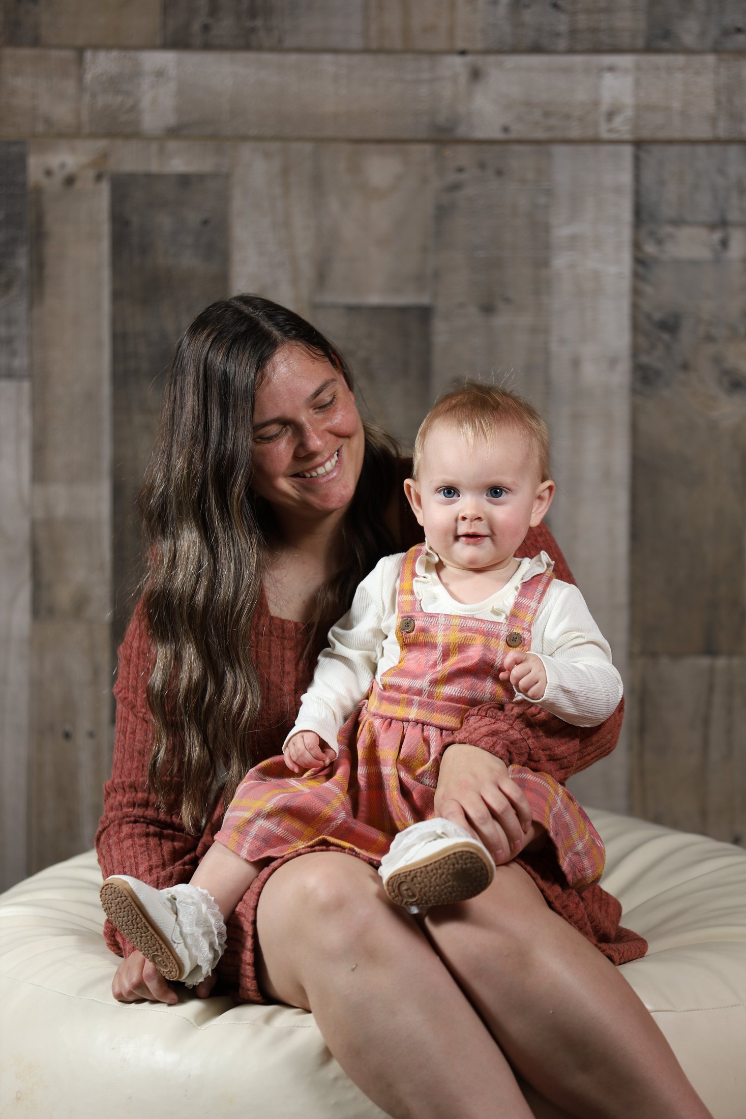 Studio portrait with mother and child against wood backdrop