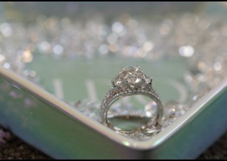 Wedding ring detail photographed on a soft green surface