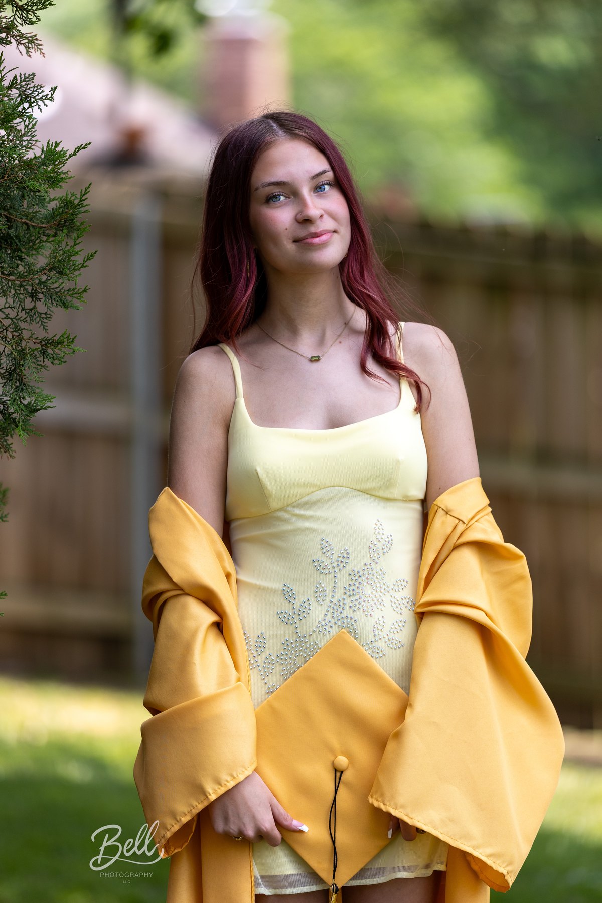 Senior portrait in a yellow graduation outfit
